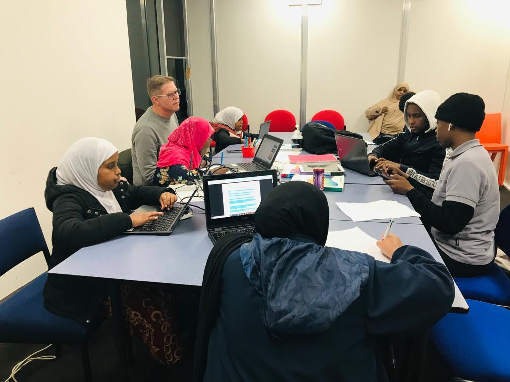 SWDA Homework Club — students working with a tutor on laptops